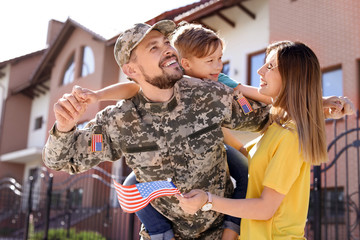 Male soldier reunited with his family outdoors. Military service