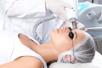 Young woman undergoing laser removal of permanent makeup in salon. Eyebrow correction