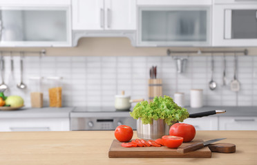 Fresh vegetables and blurred view of kitchen interior on background