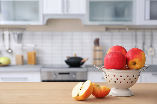 Ripe apples and blurred view of kitchen interior on background