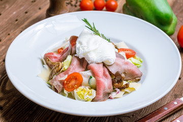 Salad with roast beef and poached egg