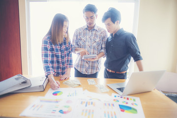 Two analysts discussing online data in front of laptop