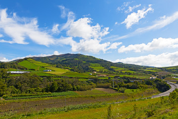 Obraz premium Picturesque landscape of Sao Miguel Island on Azores, Portugal. Hills with sweeping vistas, pastures and forests of the largest volcanic island under blue skies.