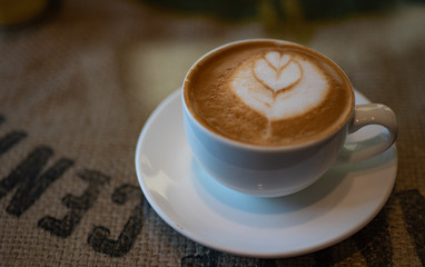 Cup of Cortado coffee on Burlap table.