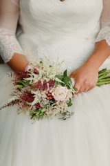 Obraz na płótnie Canvas Bride holding her bouquet in her lap during her wedding