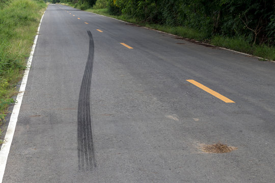 Traces of black tire brakes on the road.