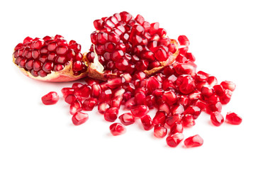 two halves of pomegranate with heap of seeds isolated on white background