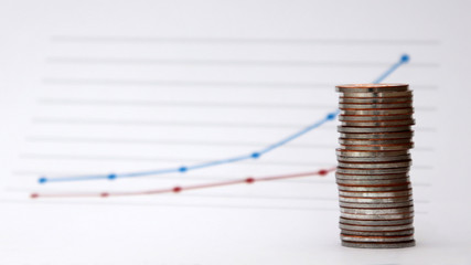 A piles of coins with a flow linear graph. The concept of a widening income gap.