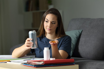 Student comparing energy drink and vitamin pill supplement