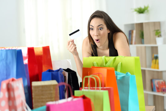 Amazed shopper looking at multiple purchases