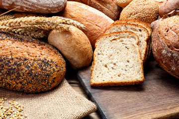 heap of bread loafs on wooden background