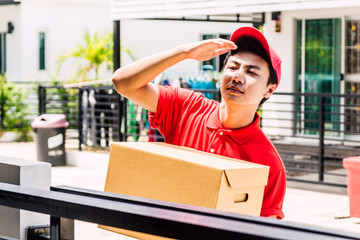 Delivery man with cardboard  box near house of customer