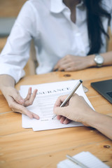 business partners signing a contract and woman showing where to sign