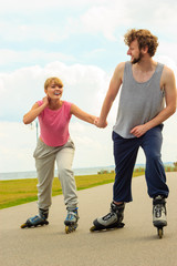 Man encourage woman to do rollerblading