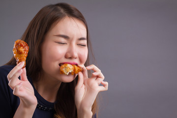woman eating unhealthy fat fried chicken; portrait of unhealthy girl eating fat fried chicken, fast...