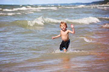 Young boy playing in the waves at the beach