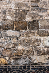 Aged stone wall with pavement in footer. Studio background, photography backdrop