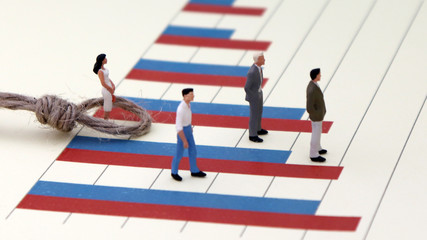 Miniature people standing on a bar graph. The discriminatory concept of women in promotion.