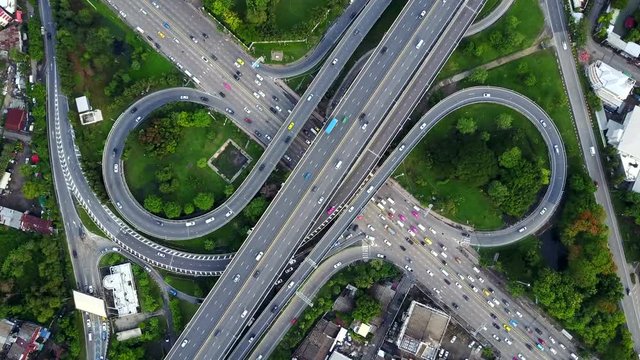 4K. Aerial view of infinity highway road interchange with busy urban traffic speeding on the road. Junction network of transportation in Bangkok, Thailand. taken by drone	