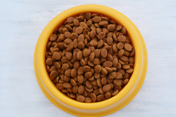 Yellow plastic bowl full with dog food