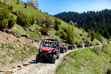 A tour group travels on ATVs and UTVs on the mountains