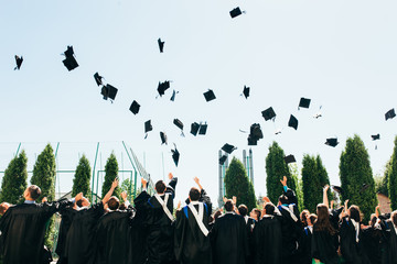Successful graduates in academic dresses, toss up their hats, goodbye study, can be used for advertising, text insertion