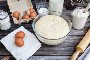 Fresh raw dough ready for baking on rustic wooden background