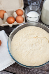 Fototapeta na wymiar Fresh raw dough ready for baking on rustic wooden background