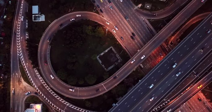 4K. Aerial view of highway road interchange with busy urban traffic speeding on the road at night. Junction network of transportation in Bangkok, Thailand. taken by drone
