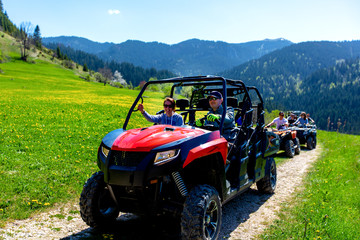 A tour group travels on ATVs and UTVs on the mountains