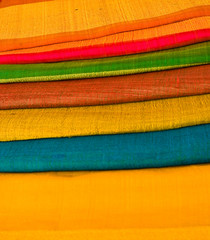 Bright bolts of cloth stacked up in vibrant colors
