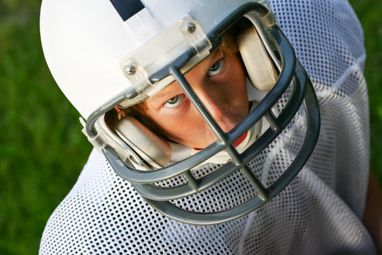 Young boy in a football helmet looking up