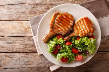 Glazed grilled steak with fresh salad of vegetables and leaves close-up. horizontal top view