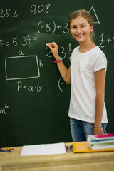 Beatiful smiling pupil in classroom at the elementary school, back to school.