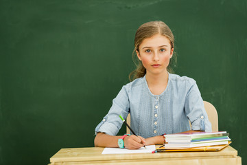 Beatiful smiling pupil in classroom at the elementary school, back to school.
