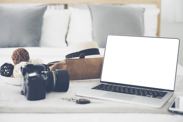 Laptop computer camera and camera on bed.