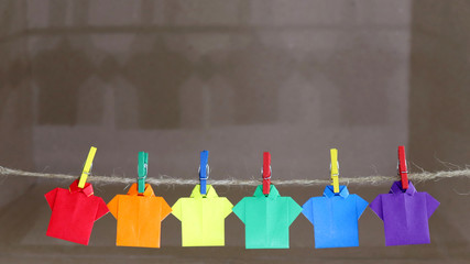 A shirt made of rainbow color paper hung on the clothesline.