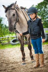Young horse riding girl, equestrian sport . Horseback girl on field.