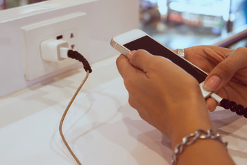 Woman hands using mobile phone while charging, Danger, Technology concept