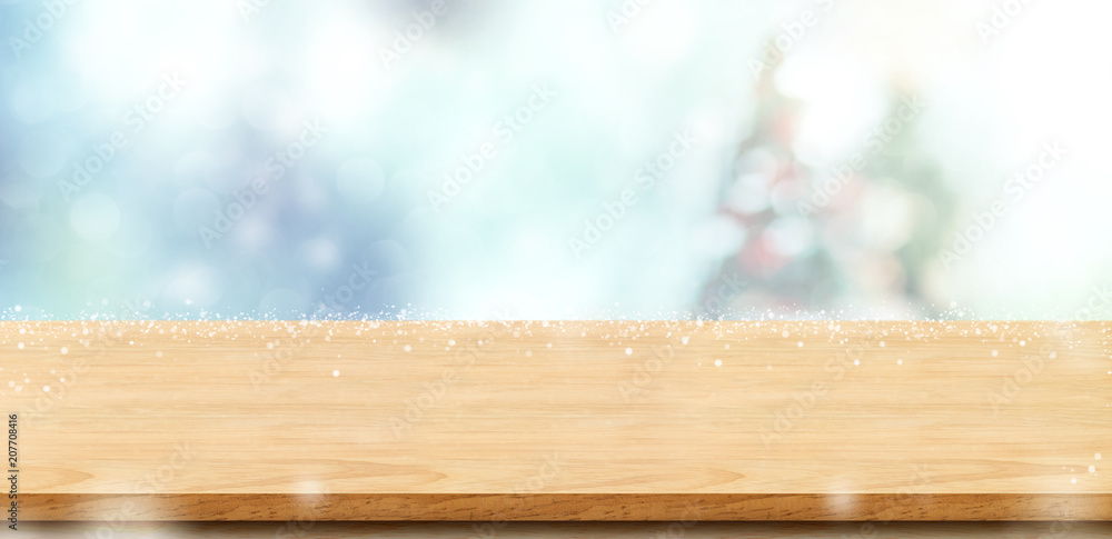 Aufkleber Empty wood board table top with abstract bokeh blur christmas tree and snow fall background with bokeh light,Holiday backdrop,Mock up banner for display or montage of product
