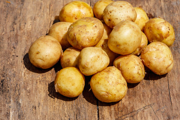 Fototapeta na wymiar New potatoes on rustic wooden table