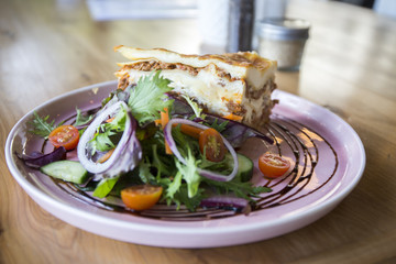 Single serving of Lasagna with some vegetables