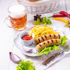 grilled bratwurst with chips and cold beer