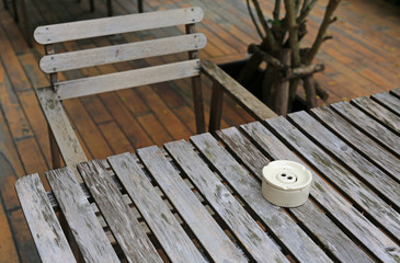 Fototapeta na wymiar wooden table and chair in the garden with ceramic cigarette ashtray. 