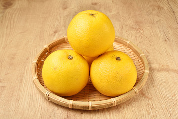 Pile of stacked  navel oranges in a bambo basket  