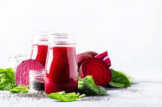 Beetroot smoothies with chia seeds in glass bottles, gray background, selective focus