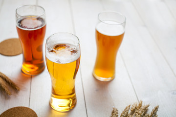 glasses of assorted beer with wheat on a wooden table background for tasting