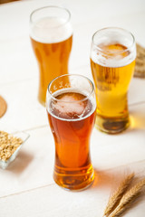 glasses of assorted beer with wheat on a wooden table background for tasting