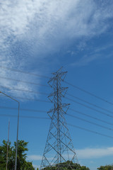 High voltage transmission towers, the sky behind bright.