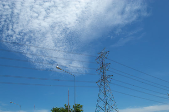 High voltage transmission towers, the sky behind bright.